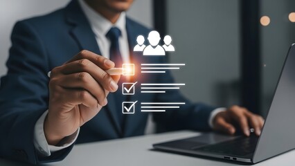 Businessman interacting with a digital human resources checklist on a screen while using a modern laptop in a dimly lit professional setting