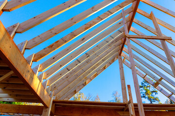 Workers build wooden beams joists roofing frame for house