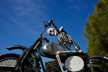 skeleton rides a motorcycle on the road