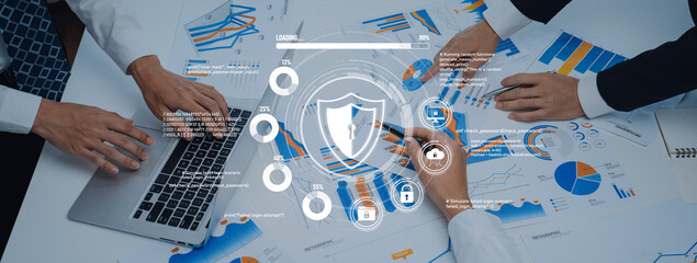 Group of business professionals working together in an office, analyzing financial charts and data on a table alongside a laptop, showcasing collaboration and strategic planning. Trope