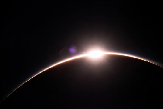 Spectacular sun rising above an alien world's curved atmospheric horizon in deep space