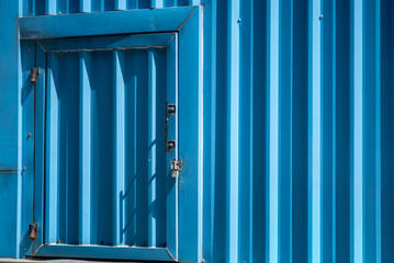 Obraz premium Bright Blue Metal Wall with Small Door