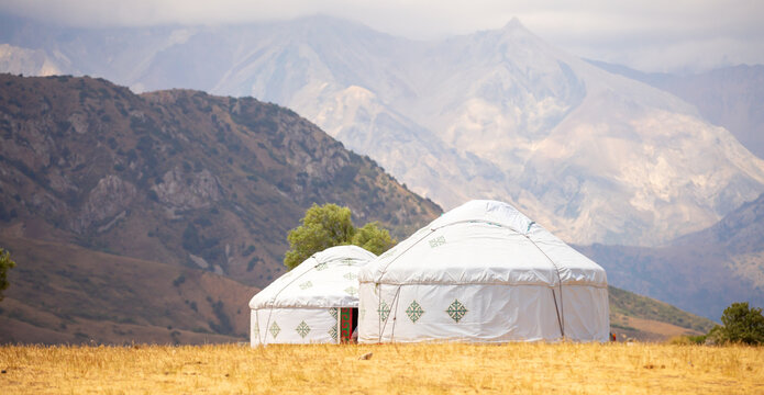 Yurt. National ancient dwelling of the peoples of Kazakhstan and Asian countries. National dwelling. Yurts against the backdrop of green meadows and highlands. Yurt camp for tourists in the mountains.