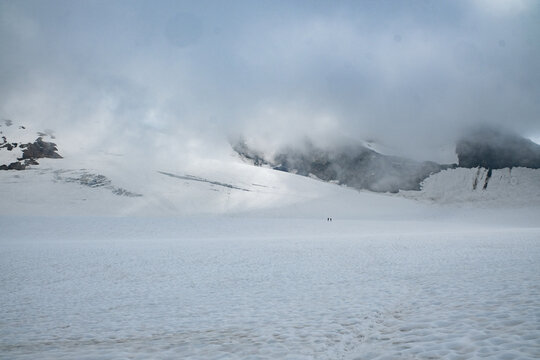 Alpinists crossing vast glacier in high alpine mountains