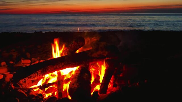 A campfire on the Black Sea coast in Tuapse. A campfire built on pebbles. A picnic at night by the sparkling logs of a campfire. A sunset on the slope of the Caucasus Mountains. 4К