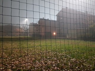Foggy morning in the countryside with a football field and houses