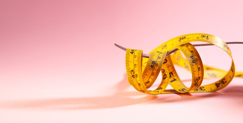 tape measure on a purple background with a pink ribbon.