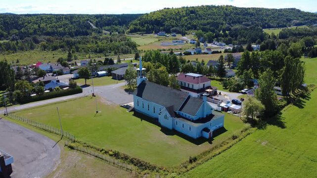 Aerial approach to the rear of the Church of Anthony of Padua, a historic Catholic religious heritage site facing the small rural village of Padoue, Quebec, Canada, 2025.