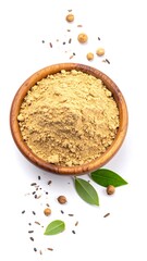 Spice powder in wooden bowl, surrounded by seeds and leaves