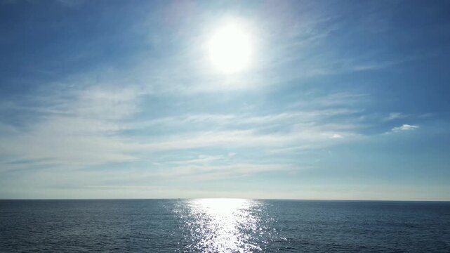 Aerial drone view, flying to the sun over blue sea, 4K nature background