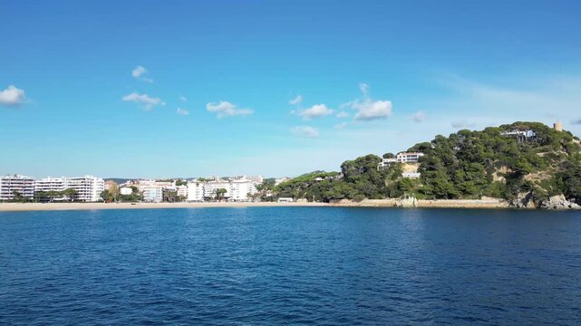 Aerial drone view, flying to the coast over blue sea, Lloret de Mar, 4K nature background