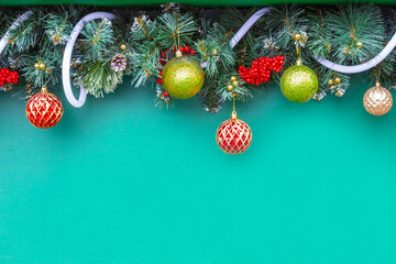 Fir garland with Christmas balls on a green background. Copy space.