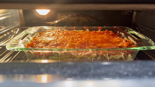 warm cheesy casserole bakes and bubbles in the oven in glass baking dish