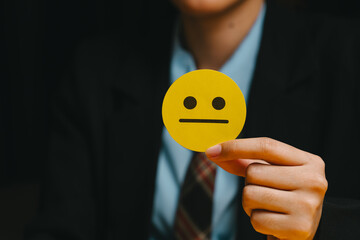 Feedback concept. Neutral face yellow emoji hand holding business suit formal wear emotion expression person human hand office attire tie