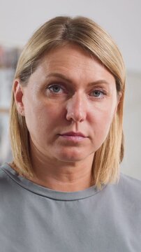 closeup woman looking down in clinic, solemn expression, light droplets on hair, soft studio lighting scenes suggest patient awaiting test results, teacher checking notes, office worker pausing