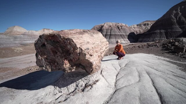 Hiker explores the unique landscape of Blue Mesa while enjoying the scenery in Petrified Forest National Park in Arizona.