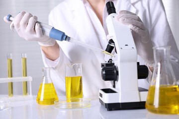 Fototapeta premium Scientist checking motor oil quality at table in laboratory, closeup