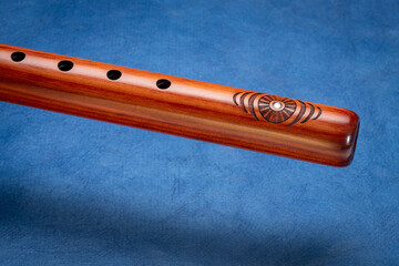 native American style flute handcrafted from aromatic cedar wood against art paper