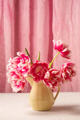 Vibrant spring pink tulip bouquet in ceramic jug