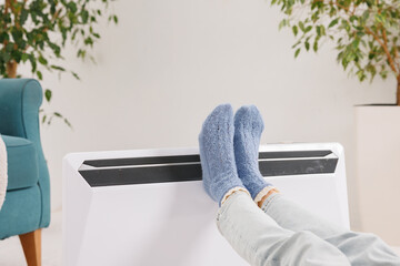 Feet in warm socks near portable electric heater in cold room at home winter heating concept © st.kolesnikov