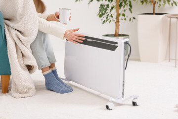 Cozy winter home routine with hot drink and portable electric heater energy saving concept © st.kolesnikov