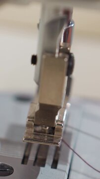 closeup sewing foot aligning stitch on metal needle plate, operator fingertip adjusting fabric, rule markings visible, heavyduty presser, focused workshop mood and steady rhythm