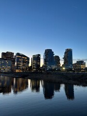 Modern Amsterdam Skyline Reflected in Water at Dusk.
Modern high-rise buildings reflected in calm water during dusk in Amsterdam city.