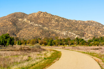 Scenic Path Leading to Rocky Mountains Under Blue Sky