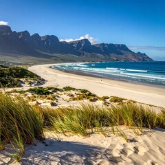 Sunny beach scene with dunes and mountains