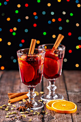 Mulled wine. Festive warm beverage served in elegant glasses, garnished with orange slices and spices, placed on rustic wooden table, creating cozy and inviting atmosphere for celebrations