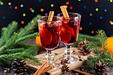 Mulled wine. Festive holiday drinks served in elegant glasses, garnished with cinnamon sticks and surrounded by pine branches, creating warm and inviting atmosphere for seasonal celebrations