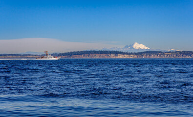 A US Coast Guard ship sails on Puget Sound with Mt. Baker in the background