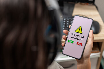 A teen holding a mobile with age verification
