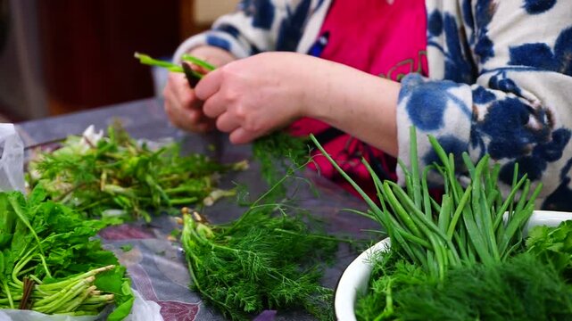 Woman peeling greens in the kitchen fof making vegetable salad