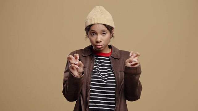 African American teenage girl making air quotes with fingers while showing sarcastic facial expression. Suggests irony, doubt, mockery. Communication, attitude, teenagers emotions.