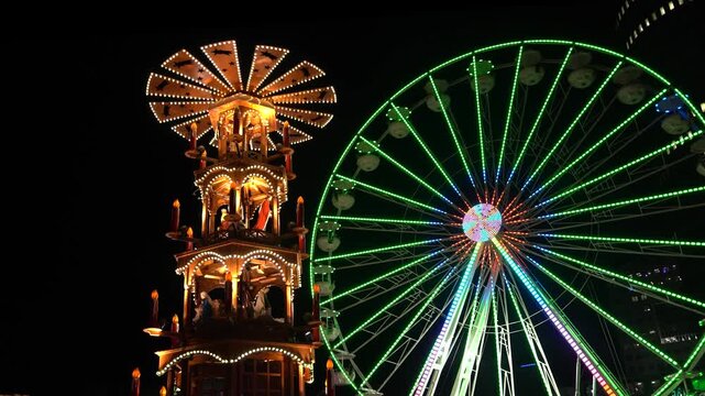 Beleuchtetes Riesenrad und Pyramide auf Weihnachtsmarkt