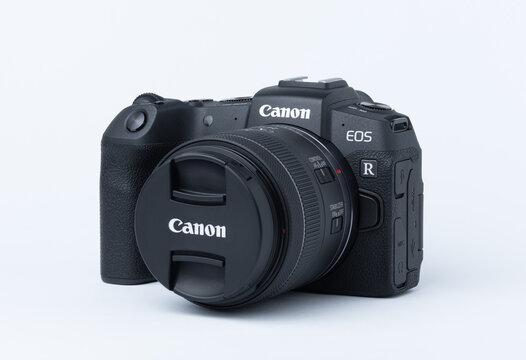 Kiew, Ukraine - December 20, 2025: Mirrorless photo camera body with zoom rf 24-50 lens on white background. Photography concept. Canon camera, photo equipment.