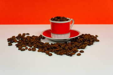 A red coffee cup with coffee beans.