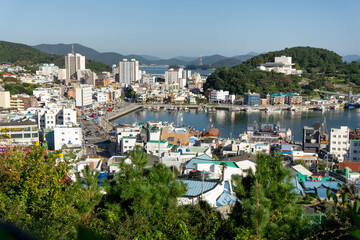 Obraz premium Tongyeong City, South Korea, October 10, 2025: Open Field View from Seoporu Wooden Pavilion where Soldiers Stand Guard at Seopilang Park in Tong Yeong City toward Houses, Homes, Village 통영 서포루 서피랑 