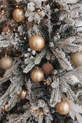 christmas background of white fir tree branches with golden balls and christmas lights. holiday background. new year. christmas tree.