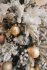 christmas background of white fir tree branches with golden balls and christmas lights. holiday background. new year. christmas tree.