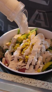 Hands Pouring Sauce into a Fresh Caesar Salad. High quality 4k footage