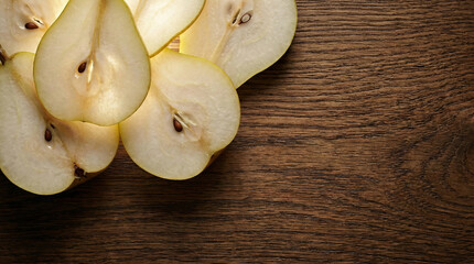 Thin pear slices backlit showing seeds on rustic wooden board