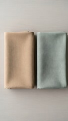 Clean top view of two folded linen fabrics on a wooden surface &mdash; product-like minimalism.