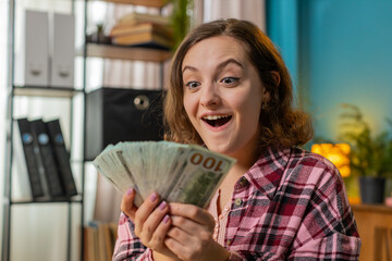 Amazed businesswoman holding fan of cash money dollar banknotes celebrate, dance, success career,...