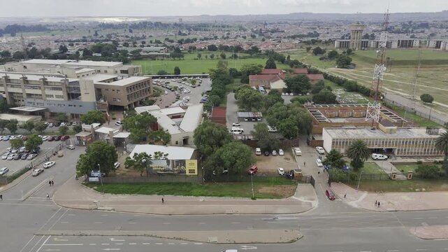 Drone facing north, flies west over Bolani Road on an overcast day in Soweto, South Africa
