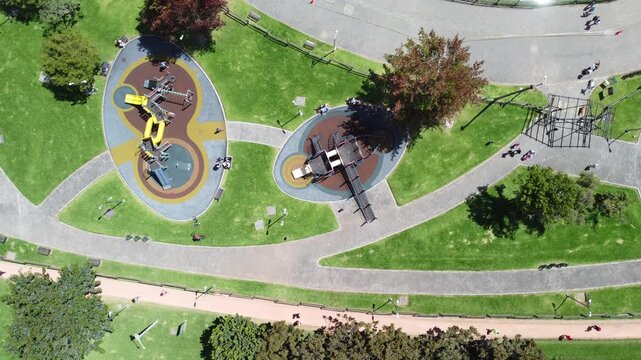 Top view Simon Bolivar natural park kids zone playground green area forest zone sunny day buildings background Bogota Colombia.