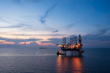 Aerial view of offshore jack up rig and offshore platform during sunset for oil and gas exploration and production.