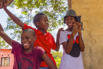 group of three happy village african teenager kids , playing at home outdoors in the yard, nature daytime © poco_bw