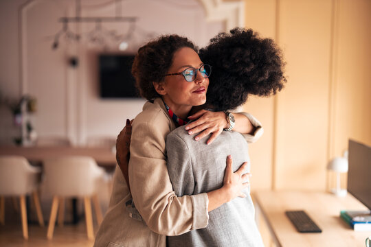 Warm Embrace Between Friends In Modern Office Setting Celebrating Support And Connection At Work